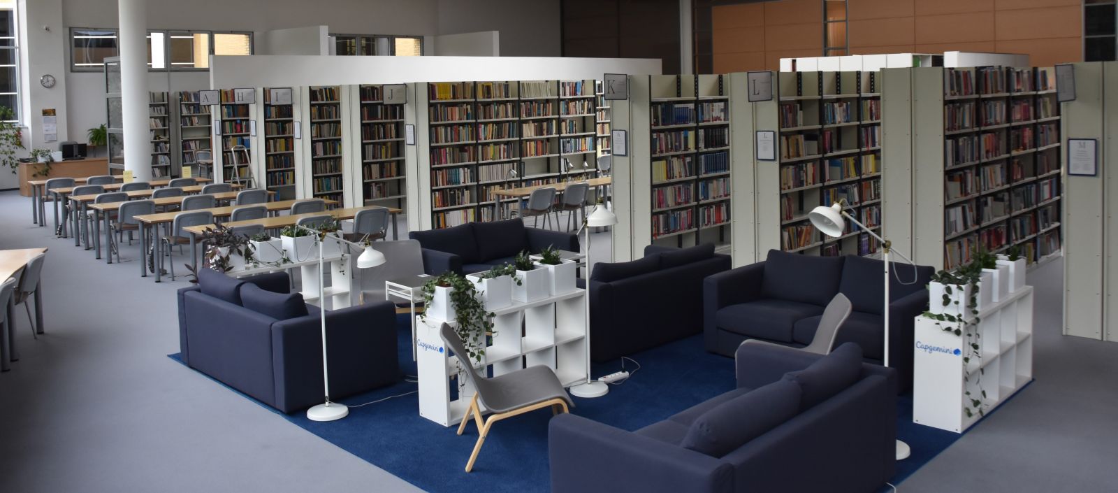 Zdjęcie wnętrza biblioteki z widokiem na regały i kanapy
